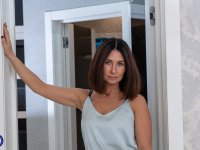 Mature brunette masturbates with a dildo after slowly stripping - Photo #1
