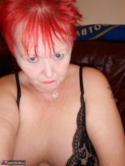 Mature redhead fatty Valgasmic Exposed exposes her bald pussy in fishnets