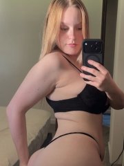 Blonde amateur takes selfies while going topless in a thong and nylon panties